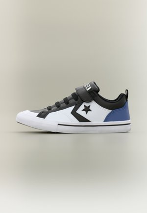 Low-top sneaker with white, black, and blue panels, a black star and chevron logo, black laces, velcro strap, and white rubber sole.