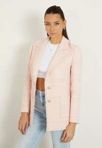 Blazer rosa chiaro realizzato in tessuto texturizzato, con design a un bottone, due bottoni dorati e una tasca frontale.