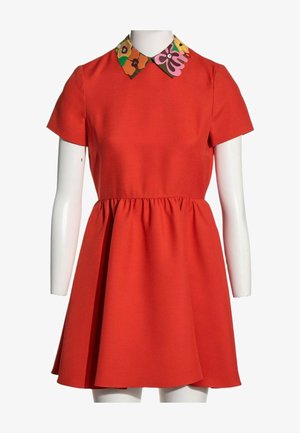 Robe rouge à manches courtes avec une taille froncée et un col à motif floral coloré sur un buste de mannequin blanc.