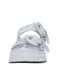 Sandali platform bianchi intrecciati con ampie cinghie intrecciate, fibbie in metallo, superficie testurizzata e suola spessa e piatta.