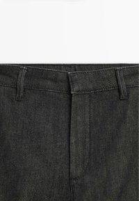 Pantaloni in denim nero con taglio dritto, vita standard, due tasche e una texture liscia con dettagli di cucitura discreti.