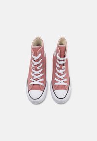 Høye sneakers i støvete rosa lerret med hvite snørebånd, gummitåhette og svarte kanter; strukturert materiale og avrundet form.