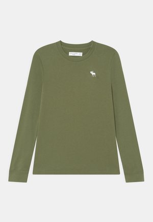 Camiseta de manga larga color verde oliva con cuello redondo y pequeño logo blanco de alce en el pecho izquierdo, talla infantil 5/6 etiqueta en el interior del cuello.