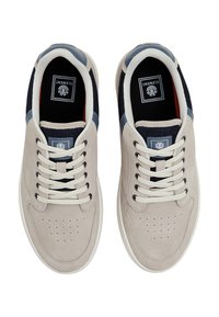 Beige suede sneakers with navy fabric accents, white laces, and perforations on the toe. Includes a logo patch on the tongue.