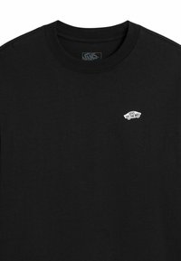 Schwarzes T-Shirt aus Baumwolle mit einem kleinen weißen "Vans"-Logo auf der linken Brust, Rundhalsausschnitt und kurzen Ärmeln.
