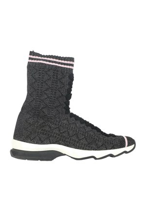 Czarny dziany sneaker typu high-top z różowymi paskami na mankiecie i czubku, biała środkowa podeszwa oraz czarna zewnętrzna podeszwa z bieżnikiem w zygzak.
