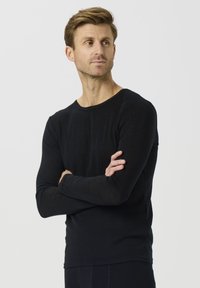 Svart langermet skjorte laget av et mykt, lett stoff med rund hals og tettsittende ermer, med et minimalistisk design.