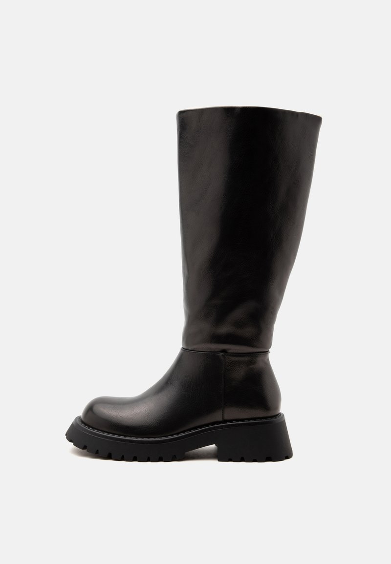 Botte haute en cuir noir avec semelle épaisse et bout arrondi, conçue pour un usage décontracté ou en plein air.