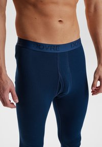 Marineblå stretch leggings med en myk tekstur, med en bred midjebånd preget med "DOVRE." Designet for en tett og figurnær passform.