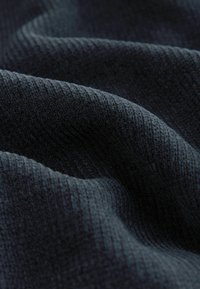 Tmavomodrý rebrovaný materiál s mäkkým, textúrovaným povrchom; obsahuje jemný vertikálny pruhový vzor a decentný lesk.