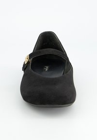 Ballerines en suede noir avec un bout arrondi, une petite sangle à la cheville avec une boucle en or et un petit talon plein.