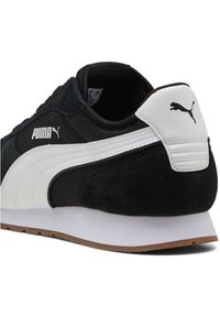 Fekete velúr és hálós sneaker fehér részletekkel, texturált hátoldallal, gumitalppal és PUMA logóval az oldalon és a sarkon.