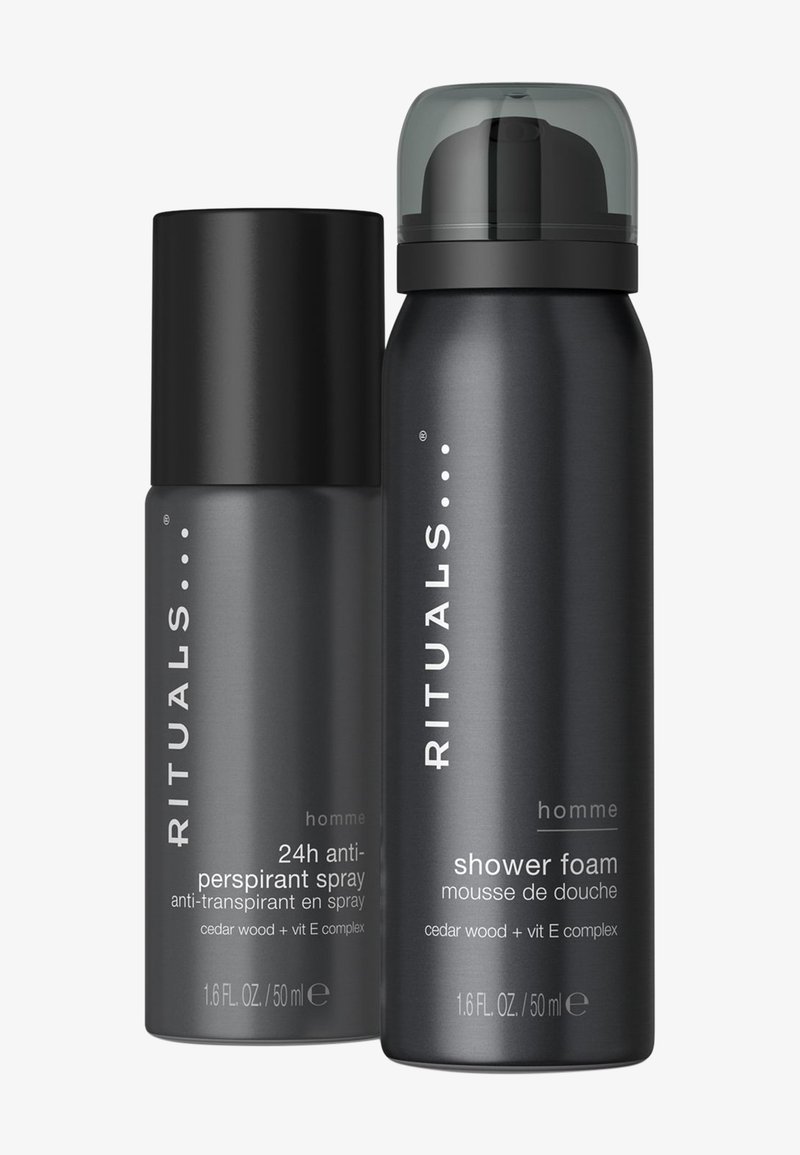 Bouteilles cylindriques noires de deux produits Rituals Homme : spray anti-transpirant 24h et mousse de douche. Les deux présentent un texte en blanc et une finition mate.