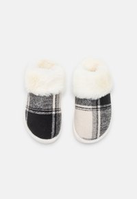 Plaid slippers featuring black and cream fleece patterns with a white faux fur cuff and a soft, rounded design for comfort.