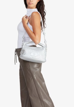 Borsa in argento intrecciato con base arrotondata, doppi manici superiori e tracolla rimovibile. Presenta una medaglia con logo sul lato.