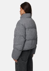 Szara kurtka puchowa z wysokim kołnierzem i pikowanym wzorem. Wykonana z teksturowanego materiału, z luźnym krojem i wypchanym sylwetką.