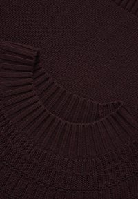 Maglione a maglia bordeaux con collare e polsini a coste testurizzati. Tessuto liscio dall'aspetto spesso e accogliente, con dettagli sottili.