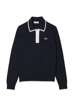 Pullover a coste blu navy con colletto polo bianco e tre bottoni, caratterizzato da un piccolo logo verde di coccodrillo sul lato sinistro del petto.