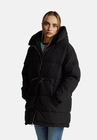 Černý péřový kabát s kapucí, který má zipový přední díl, elastický stažitelný pas a boční kapsy. Polstrovaný design poskytuje teplo.