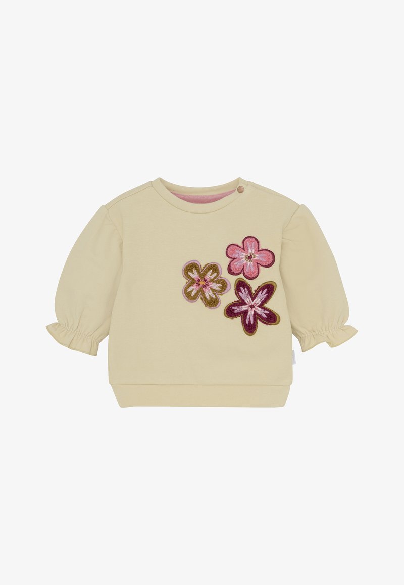 Kremowa koszulka dla małego dziecka z długim rękawem, z bufiastymi rękawami i trzema haftowanymi kwiatkami w kolorze różowym, fioletowym i oliwkowym z przodu po prawej stronie.