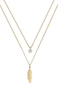 Collana a doppio strato in oro lucido con pendente in cristallo trasparente e pendente a forma di piuma. Le catene sono sottili e testurizzate, aggiungendo interesse visivo.
