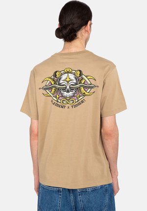 Tan cotton t-shirt with a graphic design featuring a skull and snakes on the back. Short sleeves and a relaxed fit.
