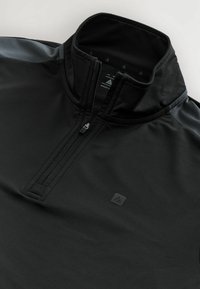 Zwarte sportpullover met kwartrits en hoge kraag, voorzien van slanke grijze schouderaccenten en een klein logo-opdruk aan de voorkant.