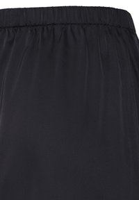 Jupe à taille élastique noire avec un tissu lisse, légèrement froncé, et une silhouette droite.