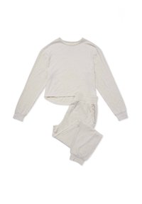 Komplet piżamowy z długim rękawem w jasnobeżowym prążkowanym materiale. Góra ma okrągły dekolt, a spodnie posiadają elastyczny pas i mankiety na końcach.