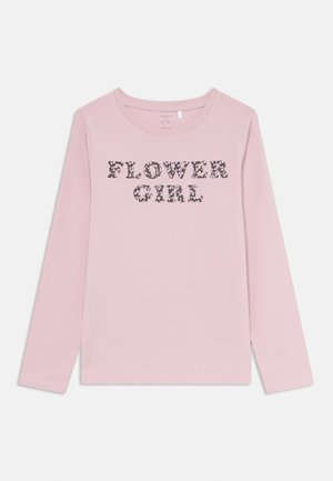 Tricou cu mânecă lungă, roz, din bumbac, cu textul "FATA FLOARE" într-un model floral închis pe față. Textură moale, decolteu rotund.
