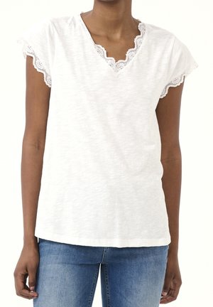 Biała koszulka z krótkim rękawem z delikatną koronkową lamówką na dekolcie i obrębie dolnym, wykonana z lekko teksturowanej tkaniny o luźnym kroju.