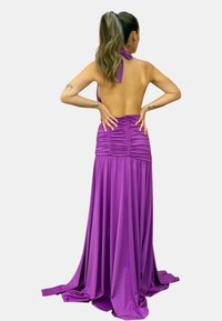 Abito da sera viola con scollatura a halter, busto arricciato, schiena scoperta e gonna fluida, realizzato in tessuto morbido e leggero.