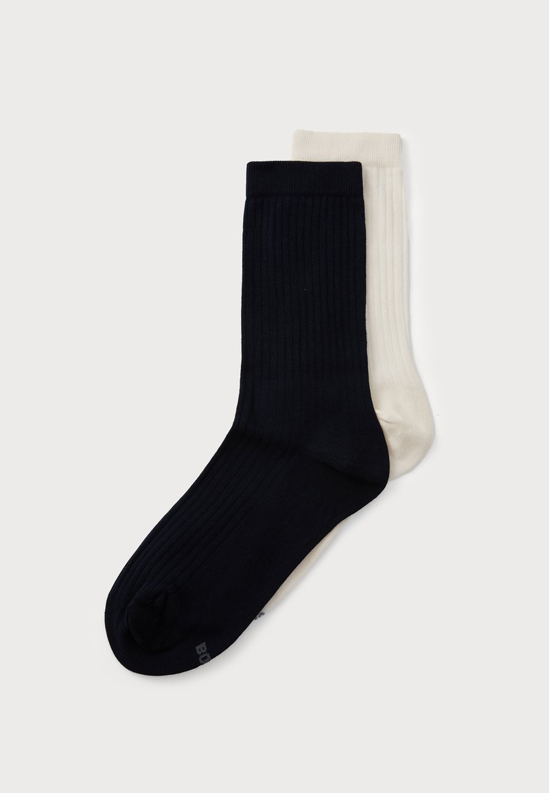 Calzini in misto cotone di colore blu navy e crema. Texture a costine, design alto alla caviglia. Cuciture delle dita visibili e colori a contrasto. Adatti per un look casual.