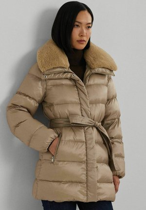 Cappotto imbottito beige con colletto in pelliccia sintetica, vita con cintura e tasche laterali con zip. Presenta una texture a trapunta e una finitura lucida.