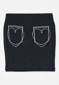Fustă tricotată neagră cu modele de buzunare în formă de inimă, conturate în alb, cu cusături întrerupte. Talie elastică pentru confort.
