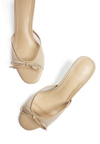 Beiga sandaletter med öppen tå, med en slät läderöverdel och nätdetaljer, som har en rosettaccent på framsidan och en något böjd form.