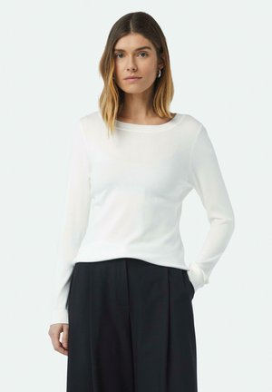 Witte langemouwtrui met een ronde halslijn en geribde manchetten, in een relaxte pasvorm en een gladde textuur, gecombineerd met zwarte broek.