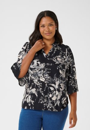 Blouse noire à motifs floraux crème et gris, avec un design pull-over, un décolleté en V et des manches trois-quarts évasées. Fabriquée en tissu léger.