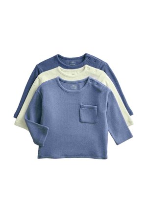 Drie gebreide babyshirts met lange mouwen in blauw, crèmekleurig en marineblauw, elk met knopen op de schouders en een klein borstzakje op het blauwe shirt.
