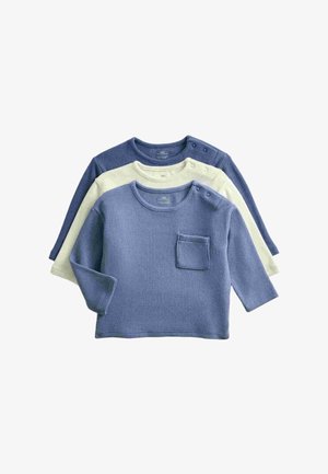 Drei langärmelige Strick-Babyshirts in Blau, Creme und Marineblau, jeweils mit Schulterknöpfen und eine kleine Brusttasche am blauen Shirt.