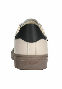 Beige Leder-Sneaker mit schwarzem Ferseneinsatz, flacher Gummisohle und strukturierten Details auf der Sohle. Minimalistisches Design mit Nähdetails.