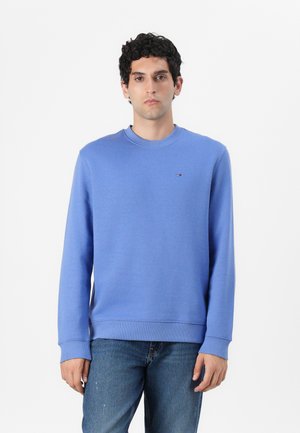 Blue sweatshirt in cotton blend with a crew neckline, ribbed cuffs and hem, featuring a small logo on the chest. Worn with denim jeans.