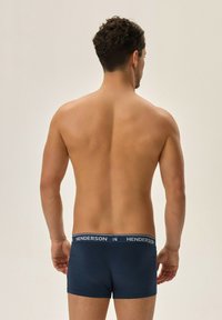 Męskie bokserki w granatowym kolorze z miękkim, elastycznym paskiem w talii, na którym widnieje logo "HENDERSON" w jasnoniebieskim kolorze. Lekki, gładki materiał.