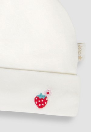 Witte katoenen beanie met een opgerolde boord, heeft een klein geborduurd rood aardbei met blauwe en roze accenten. Zachte textuur.