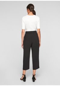 Zwarte cropped broek met een elastische tailleband, met een soepele textuur, een getailleerde pasvorm en gecombineerd met zwarte block-heeled sandalen.