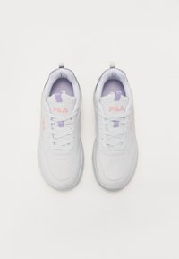 White sneakers made of synthetic material with light purple accents, textured surface, and flat laces. Features a padded collar and logo.