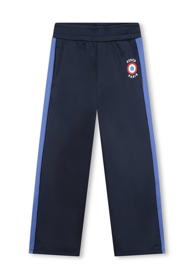 Pantalon de sport navy avec une coupe décontractée, présentant des bandes latérales bleu clair et un détail de logo rond sur la cuisse gauche. Taille élastique.