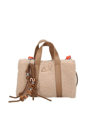 Borsa in tessuto sherpa beige con manici in pelle color cuoio, cursori delle zip arancioni e corda decorativa marrone con perline e lettere attaccata nella parte anteriore.