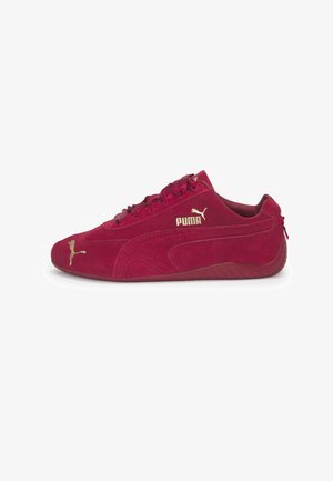 Flacher roter Puma-Sneaker aus Wildleder mit goldenem Puma-Logo an der Seite und an der Spitze, flacher Sohle und schnürsenkeln im Bandstil.