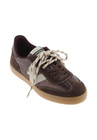 Zapatilla deportiva marrón con materiales de ante y sintéticos, que presenta un acento de ante blanco, suela de goma beige y cordones marrones y crema.